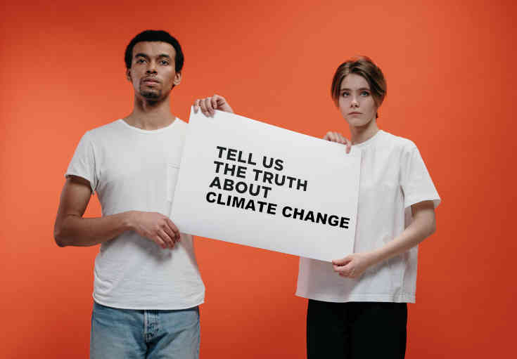 Couple holding sign asking for the truth about climate change
